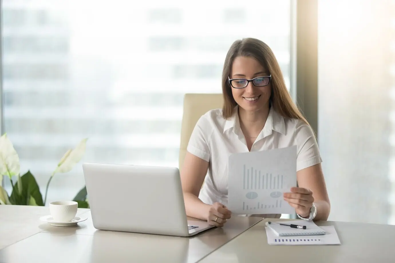Довольная женщина-предприниматель пересматривает финансовые результаты.